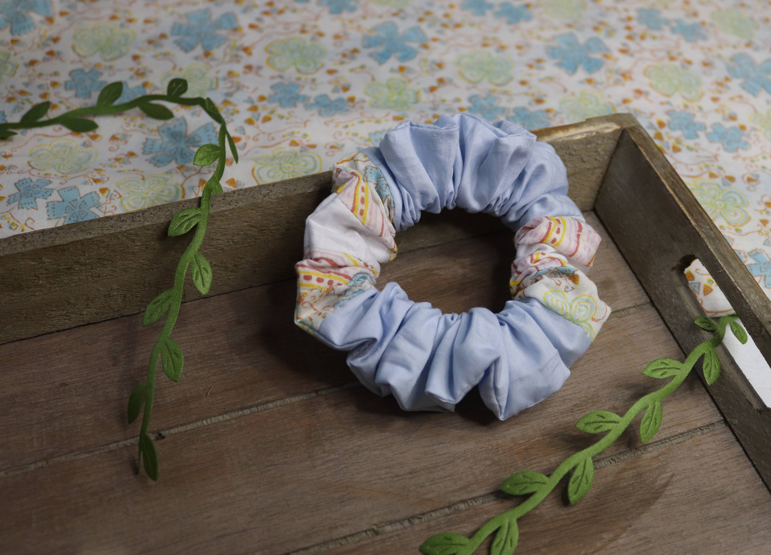 handmade hair scrunchie using the trans flag colours in small sections, angle 1